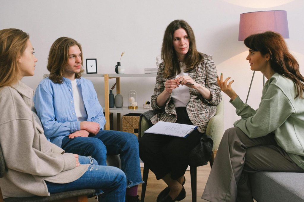 A teenage boy in a counseling session discussing with a therapist in an office setting.